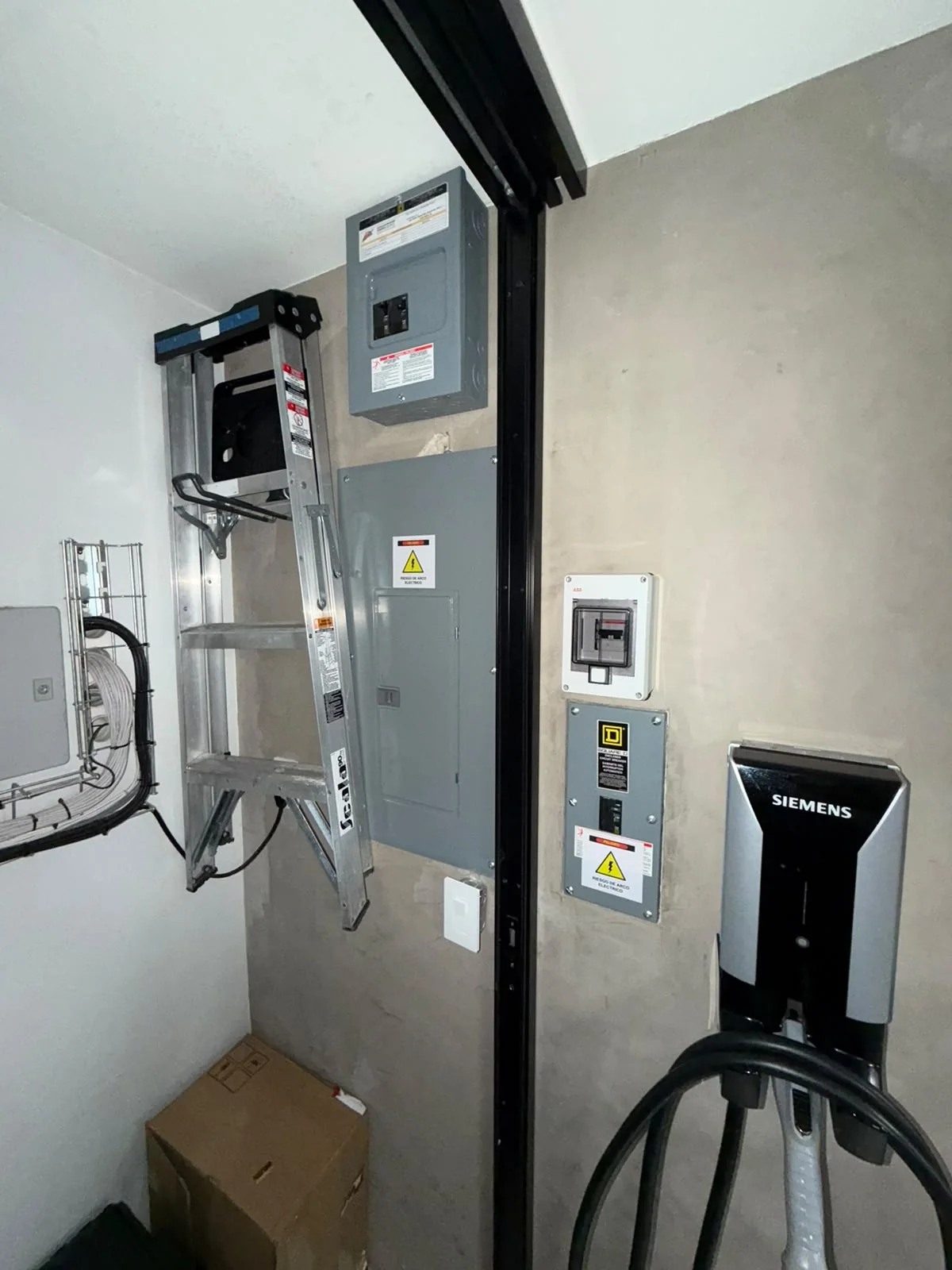 Conjunto de tableros y dispositivos eléctricos en un muro interior.